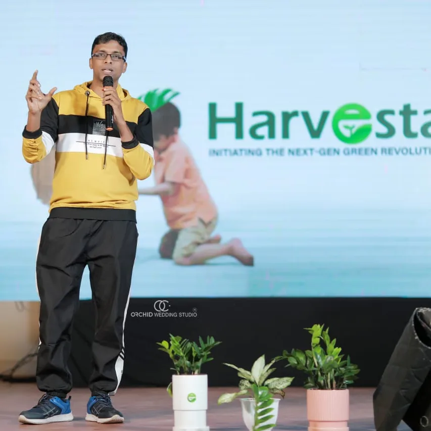 Jopher delivering keynote address on stage at Harvesta